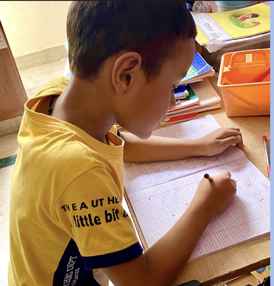 Kindergarten child writing in a notebook